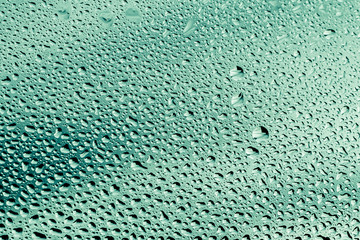 green water drops on the glass close up