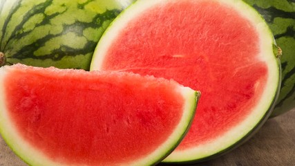 Wall Mural - Ripe watermelons on wicker tray on table on wooden background