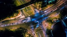 Aerial hyper lapse at night overhead of busy intersection traffic at night in Sydney, Australia with cars, trucks, buses and trains