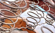 Rusted metal wire chair coils exposed in an antique wooden chair seat.  Rows of metal spirals with jute twine rope. Laid out in an array of pattern.  Chair is a vintage rocker.