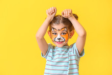 Funny Little Girl With Face Painting On Color Background