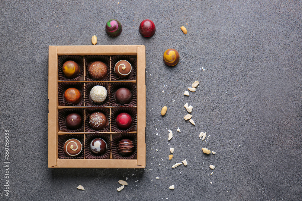 Box with delicious candies on dark background