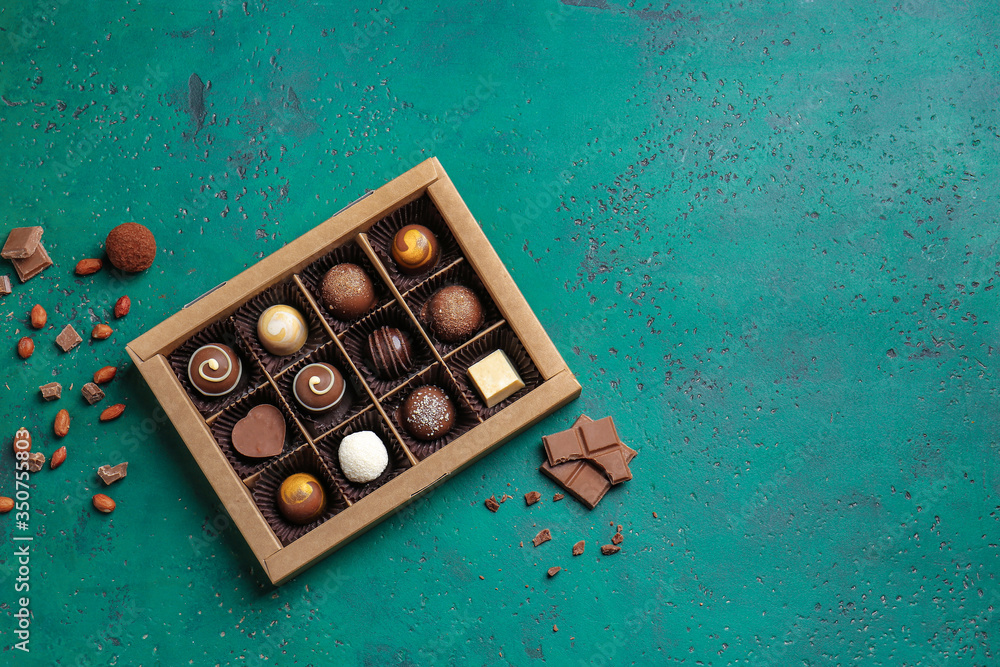 Box with delicious candies on color background
