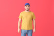 © Pixel-Shot - Handsome man in stylish cap on color background