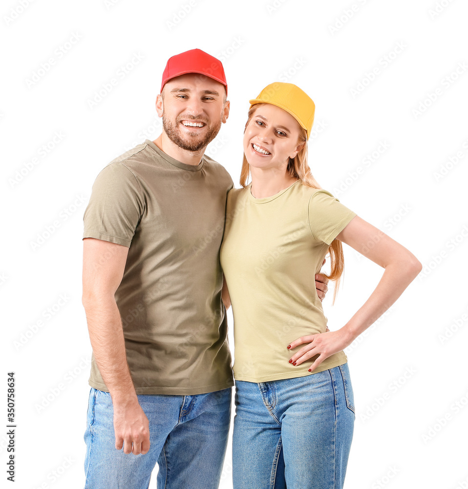 Young couple in stylish caps on white background