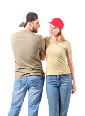 Wall Mural - Young couple in stylish caps on white background