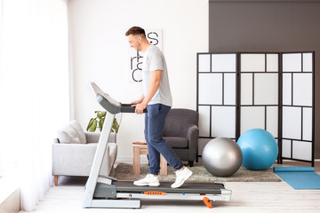 Sticker - Young man training on treadmill at home