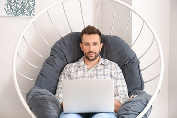 Wall Mural - Young man with laptop working at home