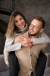 © Ольга Ивлева - Cheerful smiling couple in love hugging in the living room. Beautiful young couple at home. Concept of goof relations.