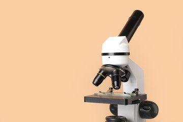 Modern microscope on color background