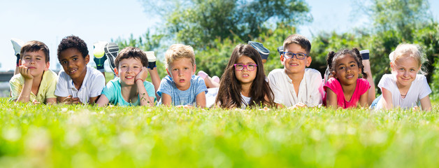 happy children lie on the green grass on a sunny day