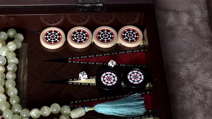 Wall Mural - A man plays backgammon and throws dice on the playing field and five and three fall out