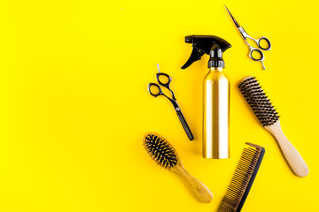 Wall Mural - Hairdresser set in beauty salon. Combs, scissors, spray on yellow desk top-down copy space