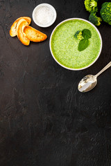 Wall Mural - Broccoli cream soup, bread, spoon on black kitchen desk top-down copy space