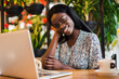 © dianagrytsku - Young african woman siting at cafe working on laptop