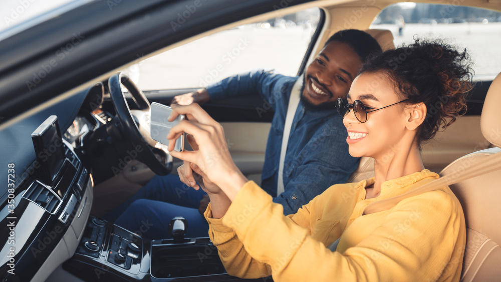 African American Couple Making Selfie Sitting In New Car, Panorama - obrazy, fototapety, plakaty 