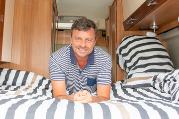 handsome man lying in modern camper van new rv in vanlife motor campervan home