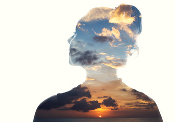 Double exposure portrait of a woman in contemplation at sunset time