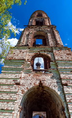 Abandoned Orthodox Church in summer against the blue sky and white clouds