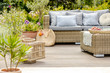 © Photographee.eu - Comfortable wicker garden furniture with grey pillows in beautiful backyard