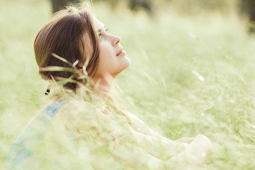 Sticker - beautiful romantic girl sitting on field of spikelets and enjoying nature, young elegant woman walking