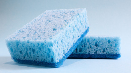 Wall Mural - Two blue sponges used for washing and erasing dirt used by housewives in everyday life. They are made of porous material such as foam. Detergent retention, which allows you to spend it economically