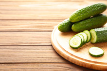 Fresh Cucumbers On A Wooden Cutting Board On Brown Wooden Background