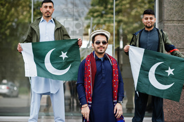 Group of pakistani man wearing traditional clothes salwar kameez or kurta with Pakistan flags.