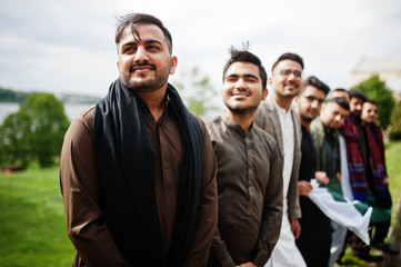 Group of pakistani man wearing traditional clothes salwar kameez or kurta with Pakistan flags.