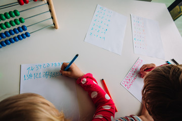 Wall Mural - boy and girl writing numbers, kids doing homework