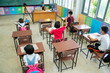 © visoot - Group of school kids wearing protective mask to Protect Against Covid-19 with teacher sitting in classroom,education,elementary school,Social Distancing,learning and people concept.