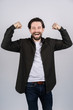 © Ivan - Young man with beard showing a gesture of power, he cheerfully laughs
