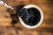 Black sturgeon caviar in silver spoon close-up.