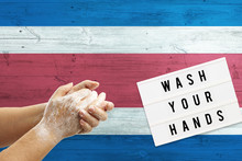 Costa Rica Flag Background On Wooden Surface. Minimal Wash Your Hands Board With Minimal International Hygiene Concept Hand Detail.