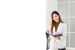 © jokekung - attractive asian female office reading a book in office, she sitting on seat and holding a book with hand, she feeling happy and smile, knowledge management