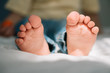 © LIGHTFIELD STUDIOS - selective focus of barefoot feet of cute boy on bedding