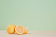 Juicy yellow lemons laying on table. Fruit for tea. Healthy lifestyle concept. Copy space. Isolated on green background