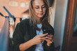 © iana_kolesnikova - Young pretty female influencer typing text message in social networks or personal blog, Positive millennial hipster girl in trendy eyeglasses chilling on balcony chatting with friends via smartphone
