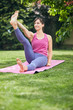 © nenadaksic - Young attractive fit yogi brunette sitting on the mat in her backyard and doing yoga.
