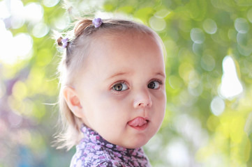 sweet and funny baby girl, closeup portrait of child, cute toddler with amazed smiling face. Two years old.