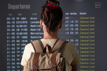 young tourist looking cancelled flights in departure screens at airport