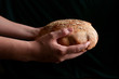 Female hands holding fresh baked sourdough bread. Home made.