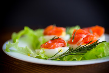 Wall Mural - boiled eggs with salted red fish and salad leaves