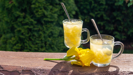 Wall Mural - pineapple jelly in glass mugs on a wooden table in the garden