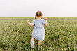 © Bostan Natalia - Little anonymous girl with two braids, running in green wheat grass field.