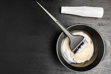 Tools for hair dyeing on the black wooden background. Colouring of hair at home