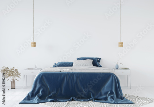 Fotografía Bedroom interior with a blue bedspread against a white wall background