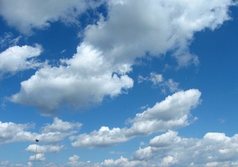 A variety of shapes of beautiful white clouds in the blue spring sky above the plain