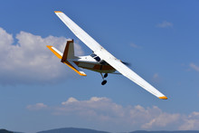 A Small Single Engine Aircraft Flying In The Blue Sky