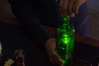 © ERNESTO - A barman opens a green bottle